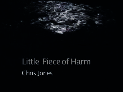 Part of the front cover of 'Little Piece of Harm' by Chris Jones showing a wet puddle ion a pavement n the dark, in an urban setting