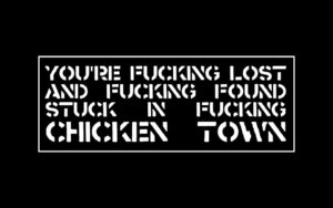 The words "You're fucking lost  and fucking found  stuck in fucking  chicken town" in white stencil font on a black background