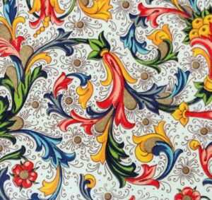 Colourful almost paisley image with curving floral designs in the foreground on a background of blue white with brown tendril like patterns