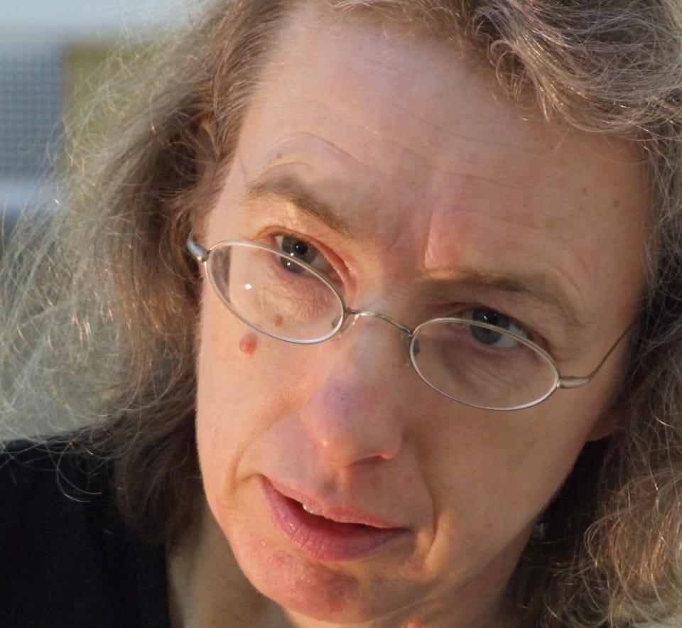 Close up of Elizabeth Burns face, her head is tilted and she is wearing oval glasses