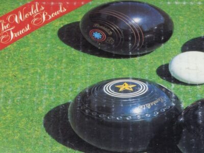 a green lawn close up with some bowling balls on it , a red flash on the top left corner reads "The Worlds finest bowls"