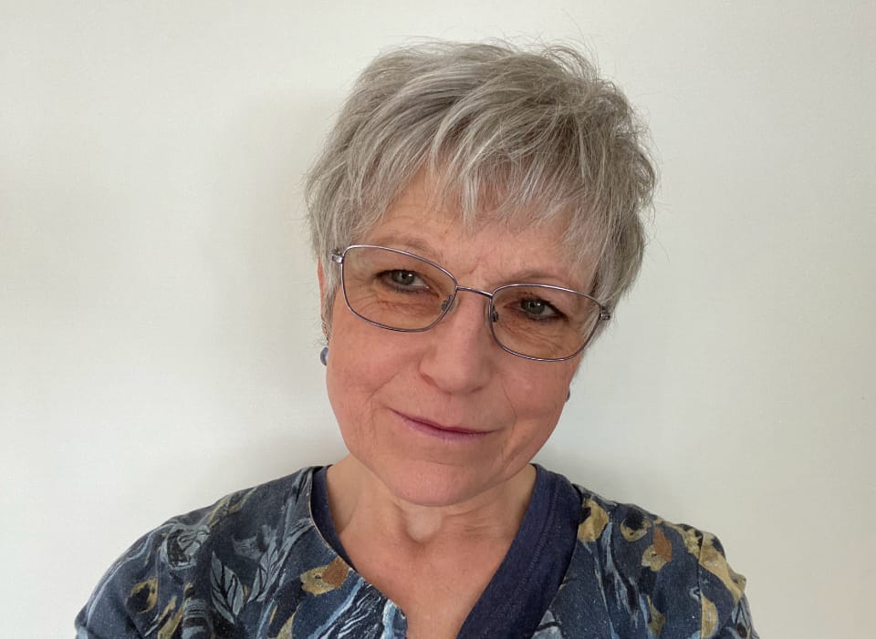Lorna with short gray hair, she is wearing glasses.