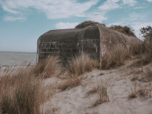 Photograph of a wartime Pillbox bunker on a beach.