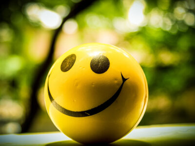 A round yellow ball with two eyes and a big smile.