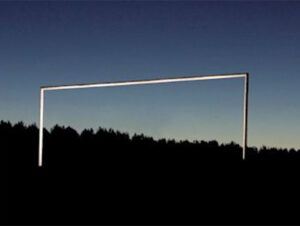 Photograph of what looks like a goalpost at dusk. Its hard to tell though, it could be a large staple superimposed on a landscape background.