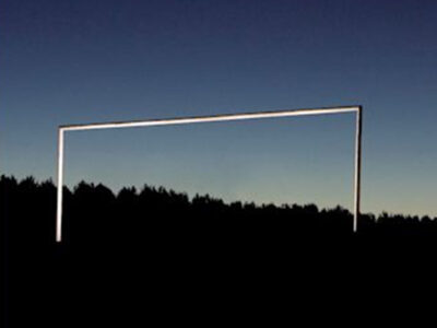 Photograph of what looks like a goalpost at dusk. Its hard to tell though, it could be a large staple superimposed on a landscape background.
