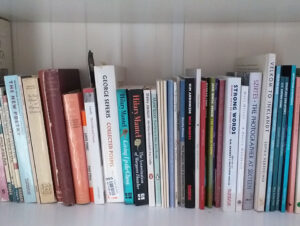 Poetry books on a bookshelf, at least forty of them. I am not going to list them all here, but many appear in the article.