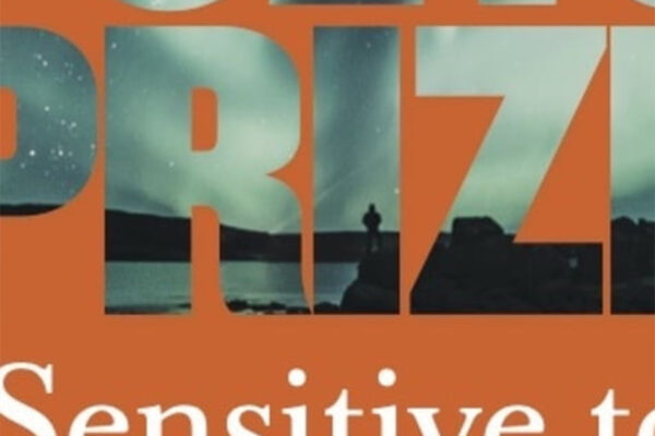 Close up of large lettering on an orange background, the lettering contains a photograph showing what looks like a shoreline.