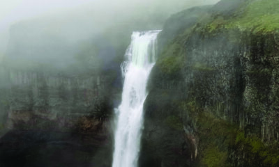 A waterfall on a foggy mountainside. It's high, and the middle of ... well, you get it.