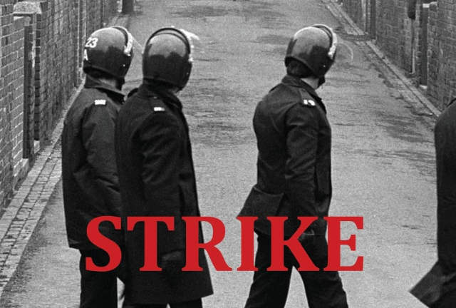 Black and white photo showing three policemen with riot helmets on a Northern backstreet.