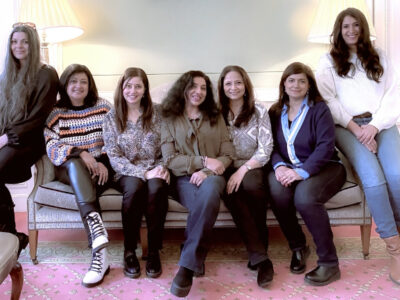 Seven women sitting on a sofa.